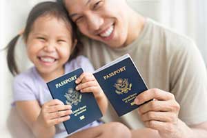 Father and daughter holding passports who have achieved successful cancellation of removal
