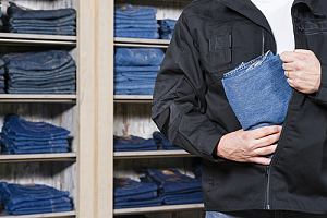 Man shoplifting a pair of jeans