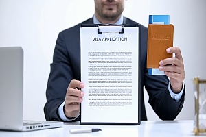 a person who is ready to give a visa interview holding a clipboard and passport