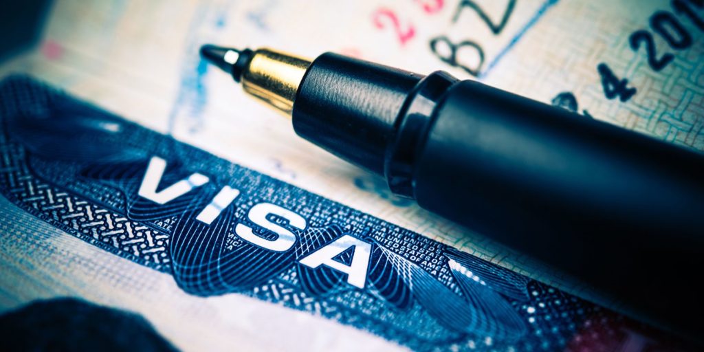 Close up of united States Visa and a pen. EB-4 visa stands for employment based fourth preference