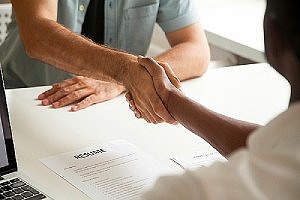 a perm labor certified employee shaking hands with employer at his new job