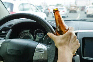 Man Driving with Liquor Bottle in Hand