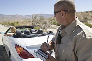 Police officer writing traffic ticket to a woman for driving without a valid license