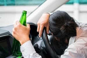 man sleeping in the car with bottle of beer in hand before getting a Aggravated DWI