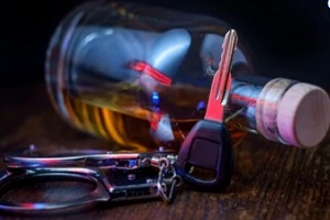car key handcuffs and alcohol bottle on the table needing VASAP