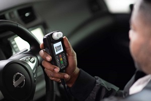 man holding a ignition interlock device asking how long do i need an ignition interlock device