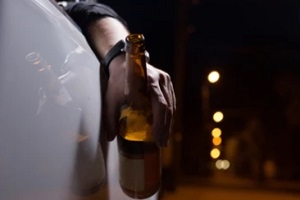 man holding beer bottle in hand while in car charged with drunk driving charge