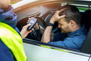 Male driver repenting after being checked positive for drunk driving