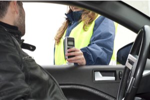 A female police officer checking BAC of a driver