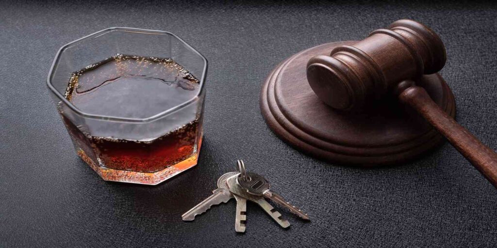 Judge gavel, car keys, and a glass of alcohol