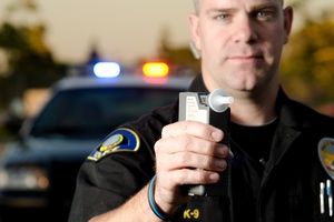 A traffic police officer holding breathalyzer to check alcohol level