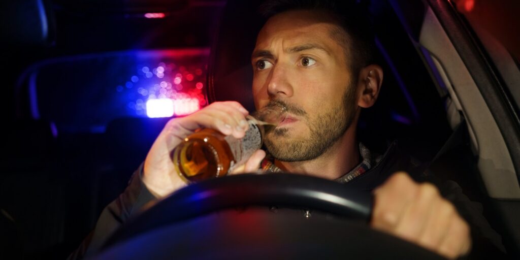 drunk man drinking alcohol while driving car