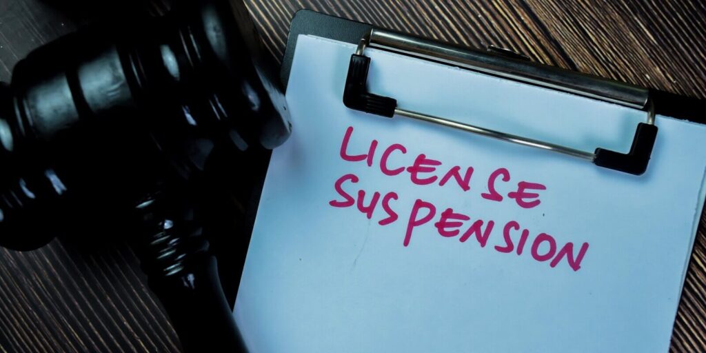 concept of license suspension write on paperwork with gavel isolated on wooden table